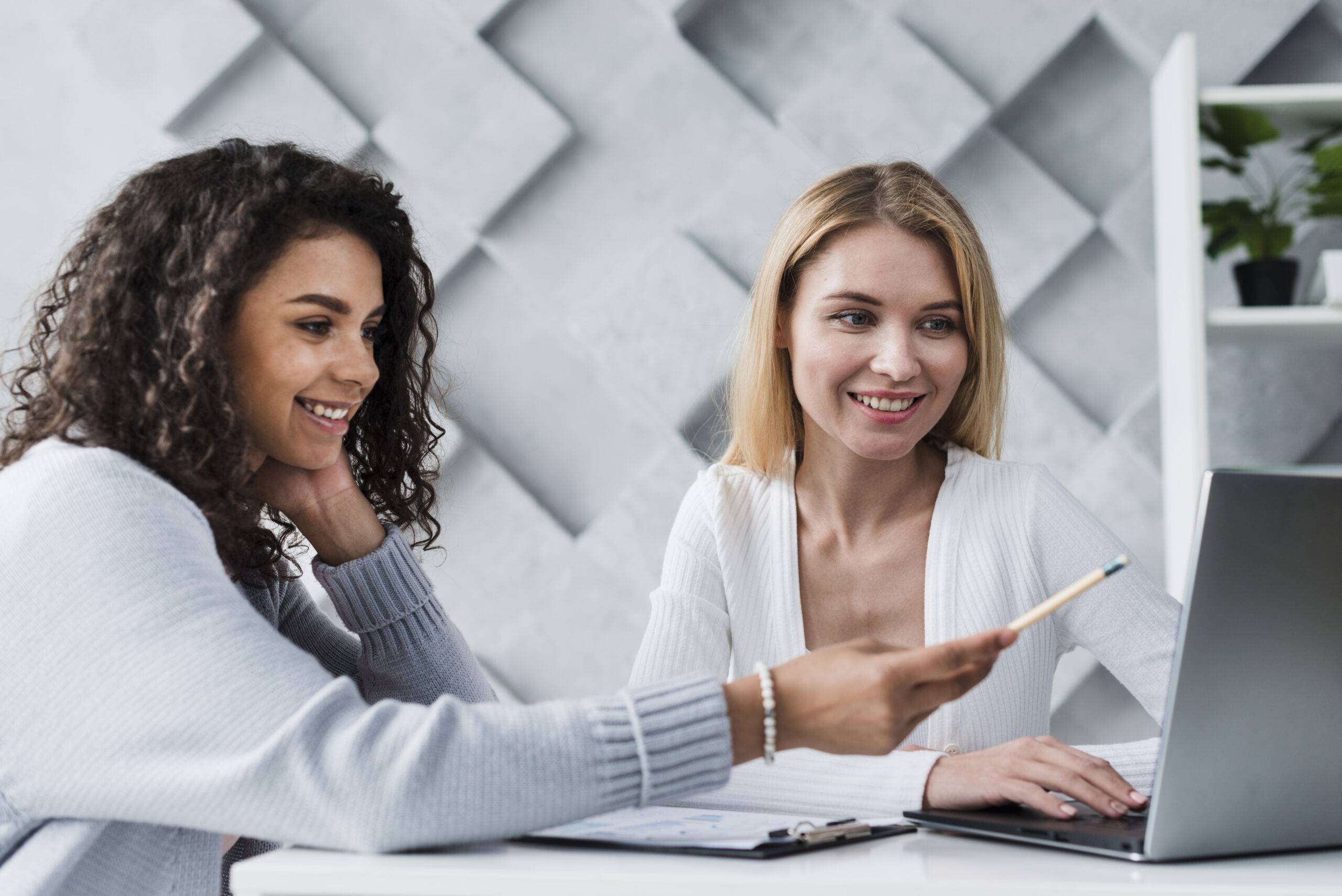 Gamificação nas empresas: duas mulheres sorrindo para a tela do computador